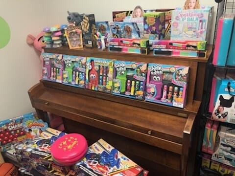 Toys piled up on a piano for a Toys for Tots Fundraiser
