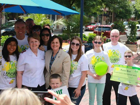 A group of our students and their families standing outside of a fundraiser for LemonAid