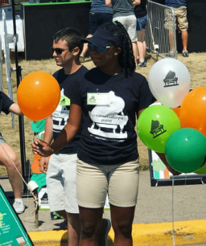 A young female student handing out balloons for St. Patricks Day fundraiser