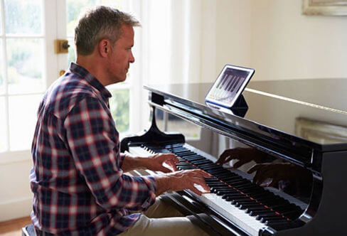 A man learning to play the piano